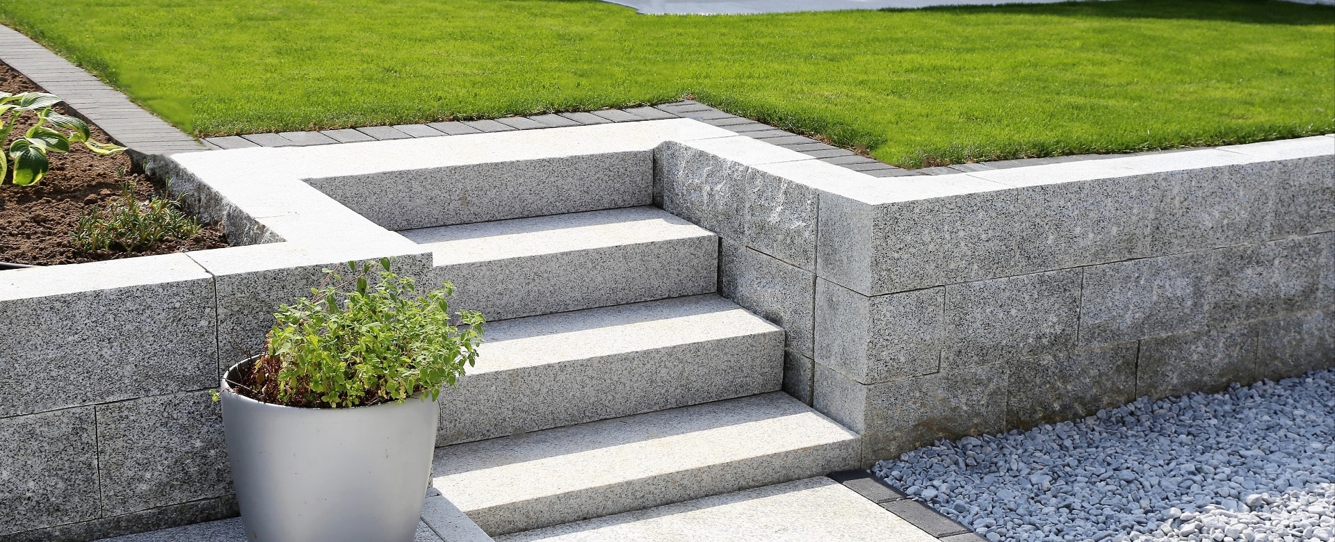 Gepflegter Ziergarten mit Granitmauer und Blockstufentreppe