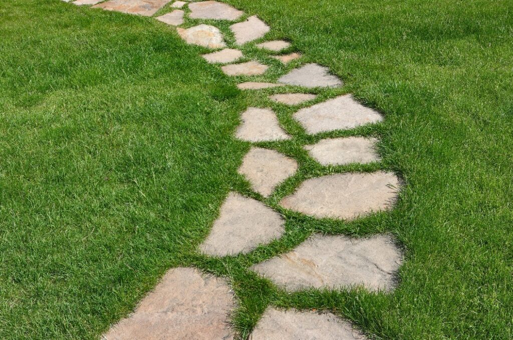 Steinweg auf einem grünen Rasen