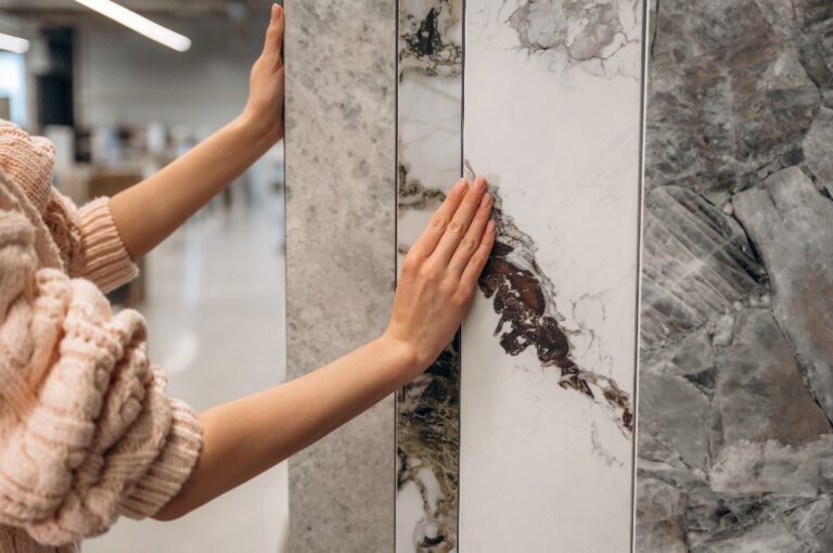 Person, die Marmorfliesen in einem Geschäft für die Inneneinrichtung auswählt