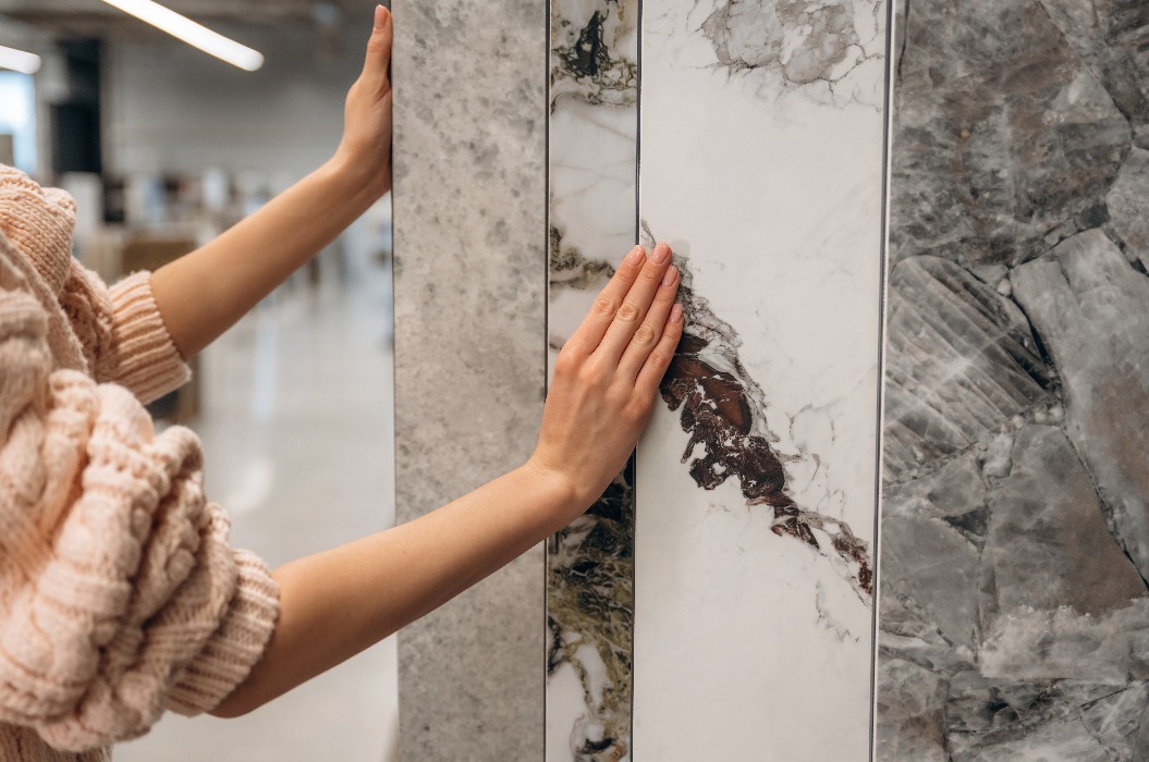 Person, die Marmorfliesen in einem Geschäft für die Inneneinrichtung auswählt